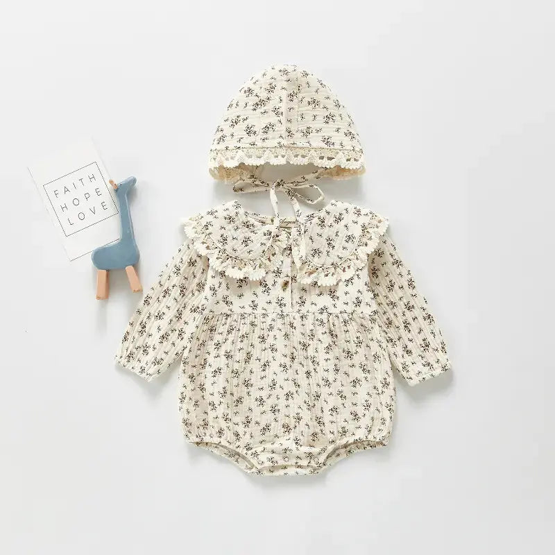 Baby meisje in beige bloemen jumpsuit set – comfortabele babykleding outfit.
