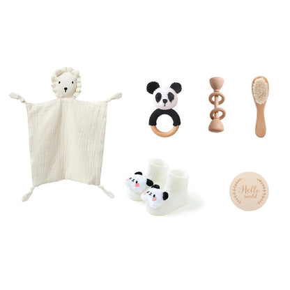 Flatlay van babycadeau: drooling towel, floor socks en houten speeltje wit panda